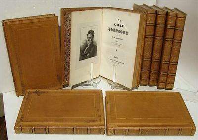 plusieurs vieux livres posés sur une table, avec la photo d'un homme en costume