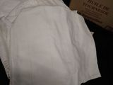 a pile of folded white shirts on a black surface