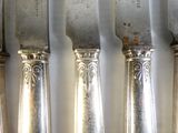 cinq cuillères en argent posées les unes à côté des autres sur une table