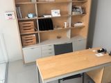 a desk with a chair and a bookcase in the corner