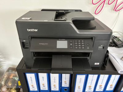une imprimante posée sur une pile de classeurs