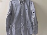 une chemise rayée bleue et blanche accrochée au mur