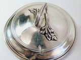 a silver plate with a bird on it on a white table
