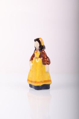a small figurine of a woman in a yellow dress