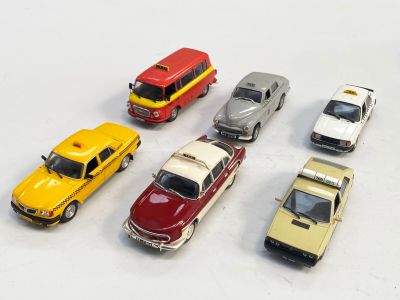 plusieurs petites voitures sont alignées sur une surface blanche