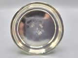 an antique silver plate with a silver rim on a white surface