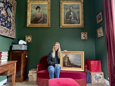 une femme assise sur une chaise rouge dans une pièce verte