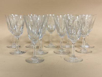 six verres à vin transparents sont alignés sur une table