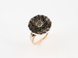a close up of a ring with black diamonds on a white background