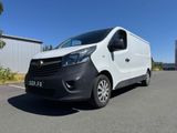 une camionnette blanche garée sur un parking à côté d'un bâtiment