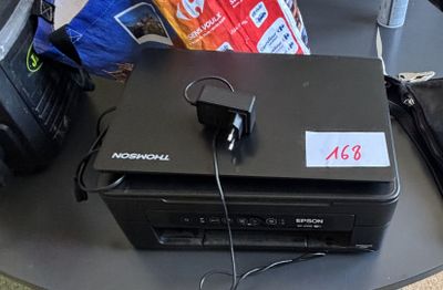 un ordinateur portable posé sur une table, à côté d'un paquet de chips