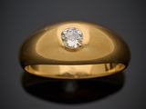 gros plan d'une bague en or avec un diamant au centre