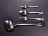 three silver spoons and a fork on a black surface