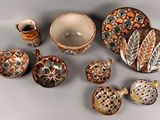 many pieces of pottery that are sitting on a table