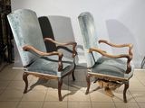 pair of blue velvet upholstered armchairs with carved arms