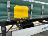 un camion vert avec une pancarte jaune sur le côté
