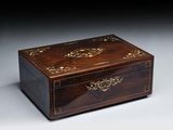 une boîte ancienne en bois dont le couvercle est orné d'un motif décoratif
