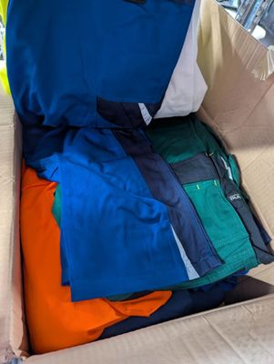 a cardboard box filled with many different colored shirts