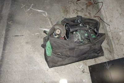 un sac rempli d'appareils électroniques posé par terre