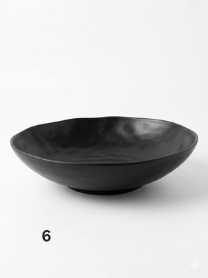 un bol noir posé sur une surface blanche
