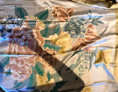 une photo d'un lit avec une couette à motifs floraux et une paire de ciseaux