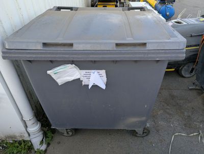 a trash can sitting outside of a building next to a building
