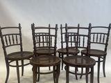 four wooden chairs are lined up in a row on a white background