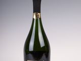 une bouteille de champagne posée sur une table, à côté d'une bouteille de vin