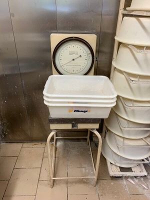 une pile de seaux posée à côté d'une horloge dans une pièce