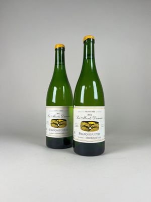 two bottles of wine sitting next to each other on a table