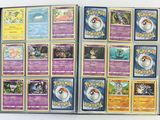beaucoup de cartes Pokémon dans un album posé sur la table