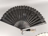 a black fan sitting on top of a table next to a mirror