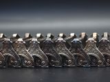 a group of silver figurines sitting on a black surface