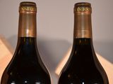 two bottles of wine sitting next to each other on a table