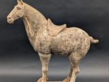 an old statue of a horse with a saddle on it ' s back