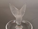 a glass bird that is sitting on top of a wine glass