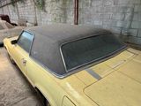 a yellow car parked in a garage next to other cars