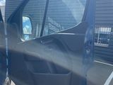 the door of a blue van is open in a parking lot