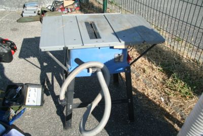 une table posée à même le sol, avec un tuyau devant elle