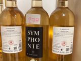 three bottles of wine sit on a counter in front of a wall
