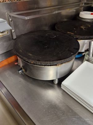 stainless steel counter top with plates and pans on top of it