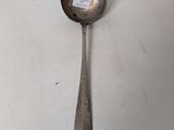 an old spoon with a sticker on it sitting on a table