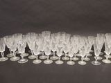 twelve wine glasses lined up in a row on a black surface