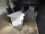 a white desk with a black chair and a computer on it