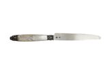 a knife that is sitting on a white surface