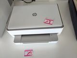 a laptop computer sitting on a desk with a printer next to it