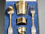 un service d'argenterie présenté dans un coffret, comprenant une fourchette, une cuillère et un repose-cuillère