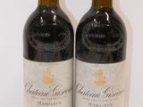 two bottles of red wine sitting next to each other on a table
