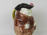 a ceramic figurine of a man wearing a hat and scarf