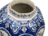 a blue and white vase sitting on a white surface